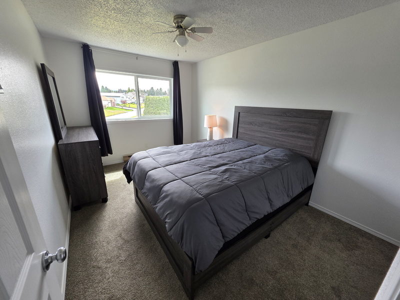 Chambre ensoleillée avec lit double et grande fenêtre