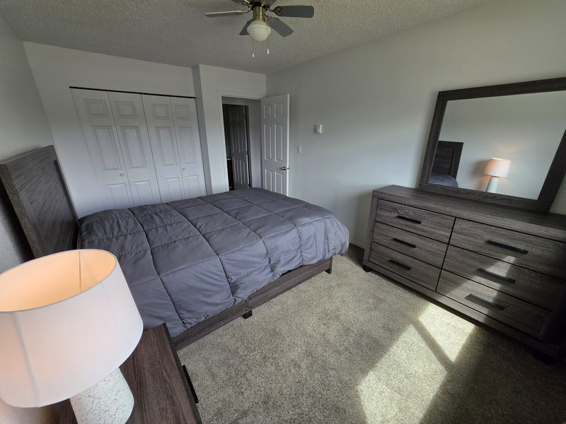 Chambre avec lit, commode et miroir