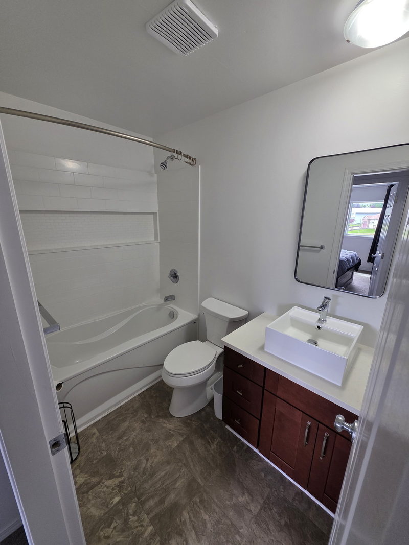 Salle de bain avec vanité en bois foncé et baignoire