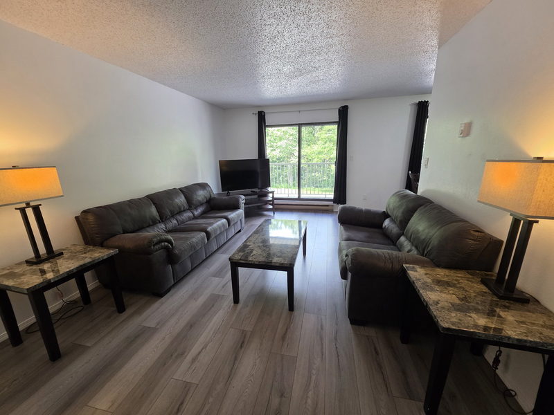 Salon avec sectionnel en cuir et téléviseur mural